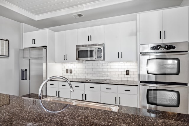 1901 Post Oak Blvd Unit 609, Houston, TX 77056 - kitchen with stainless steel appliances, dark stone countertops, tasteful backsplash, and white cabinetry
