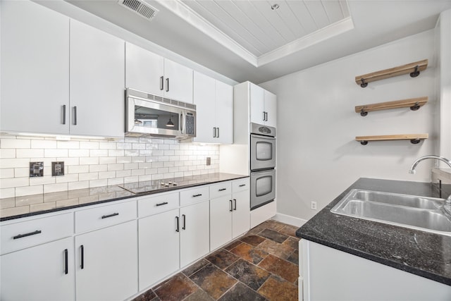 1901 Post Oak Blvd Unit 609, Houston, TX 77056 - kitchen featuring appliances with stainless steel finishes, open shelves, a tray ceiling, stone tile flooring, and decorative backsplash