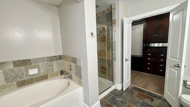 1901 Post Oak Blvd Unit 609, Houston, TX 77056 - bathroom with stone tile flooring, a garden tub, and a stall shower