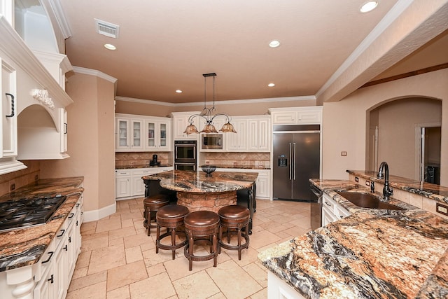 42 Lake Sterling Gate Dr, Spring, TX 77379 - kitchen with stainless steel appliances, a kitchen island, stone tile flooring, a breakfast bar, and decorative backsplash