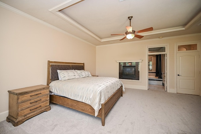 42 Lake Sterling Gate Dr, Spring, TX 77379 - bedroom with a raised ceiling, light colored carpet, crown molding, a glass covered fireplace, and a ceiling fan
