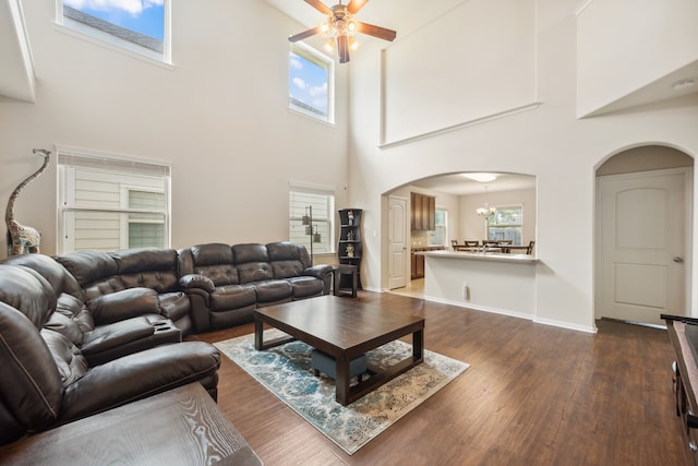 11134 Sun River Falls Dr, Humble, TX 77396 - living room with arched walkways, ceiling fan, dark wood-style floors, a towering ceiling, and a chandelier