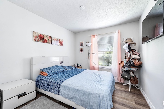 18446 N Willow Bluff Rd, Katy, TX 77449 - bedroom featuring wood finished floors and a textured ceiling
