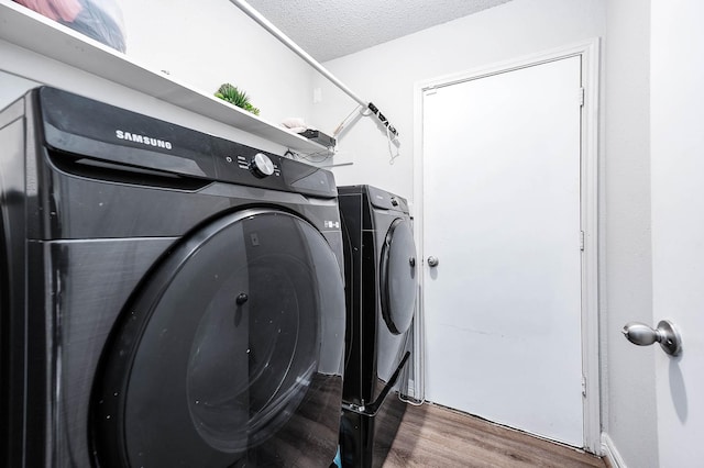 18446 N Willow Bluff Rd, Katy, TX 77449 - laundry room featuring washer and clothes dryer, wood finished floors, and a textured ceiling