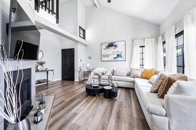 18446 N Willow Bluff Rd, Katy, TX 77449 - living room with wood finished floors, high vaulted ceiling, a fireplace, and beam ceiling