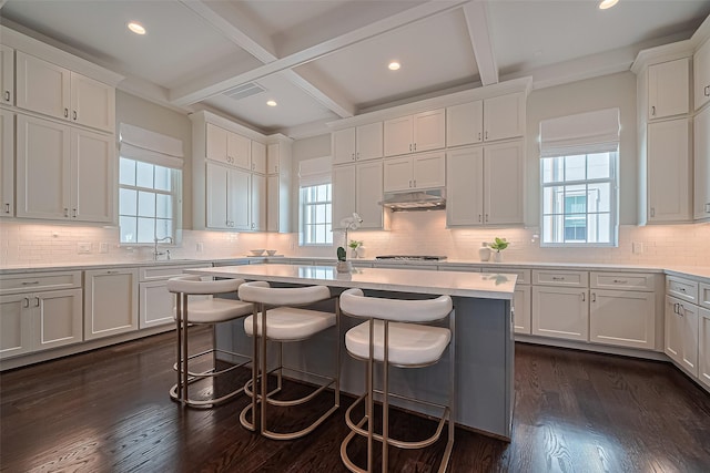 817 Blackshire Ln, Houston, TX 77055 - kitchen featuring plenty of natural light, a kitchen bar, white cabinetry, beam ceiling, and recessed lighting