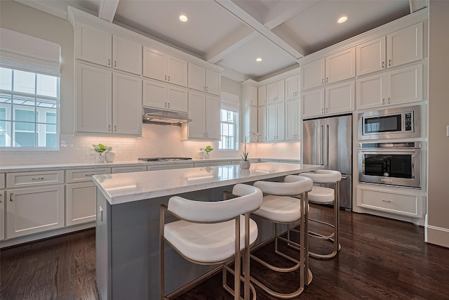 817 Blackshire Ln, Houston, TX 77055 - kitchen featuring stainless steel appliances, dark wood-style flooring, white cabinetry, beamed ceiling, and backsplash