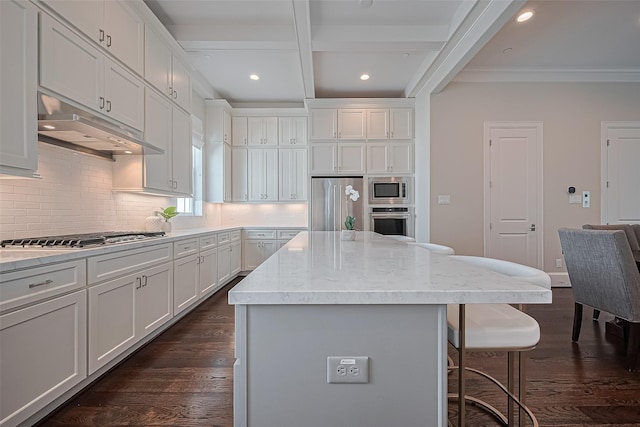 817 Blackshire Ln, Houston, TX 77055 - kitchen with appliances with stainless steel finishes, a kitchen breakfast bar, under cabinet range hood, tasteful backsplash, and dark wood finished floors