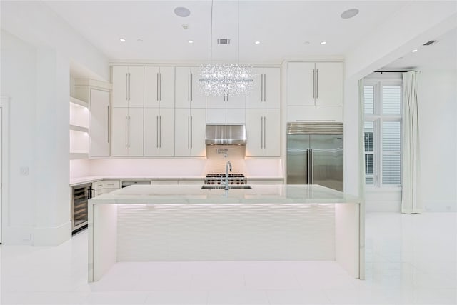 2425 E Seaside Dr, Galveston, TX 77550 - kitchen featuring stainless steel built in fridge, beverage cooler, a chandelier, a center island with sink, and ventilation hood