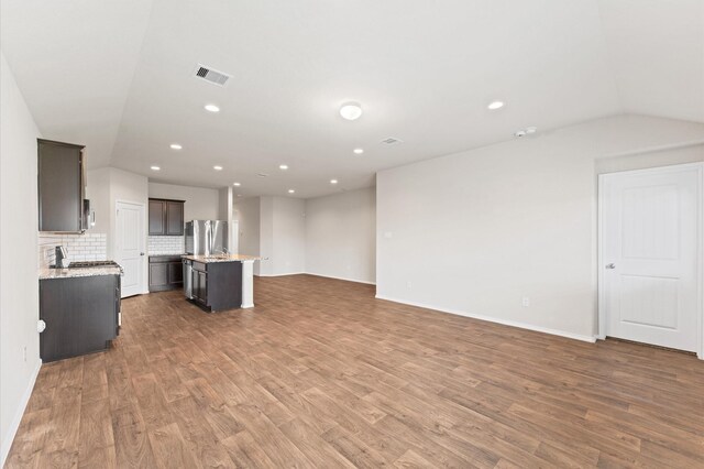 919 Bright Lotus Ln, Rosharon, TX 77583 - unfurnished living room featuring lofted ceiling, light wood finished floors, and recessed lighting