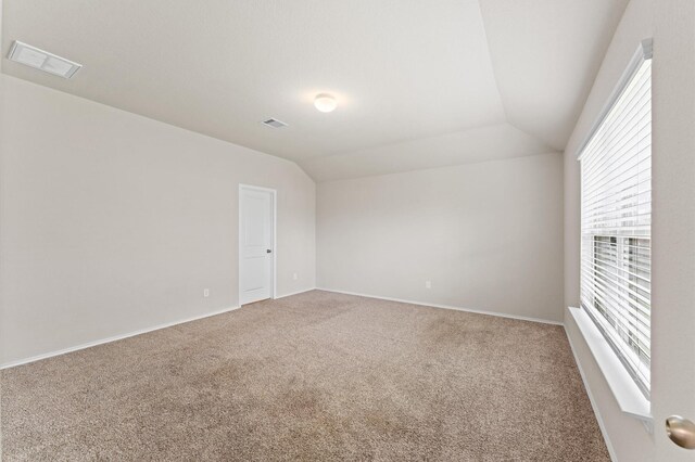 919 Bright Lotus Ln, Rosharon, TX 77583 - empty room featuring carpet flooring, vaulted ceiling, and healthy amount of natural light