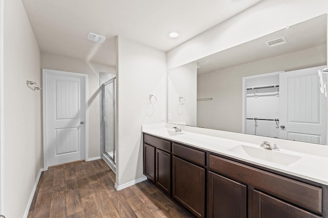 919 Bright Lotus Ln, Rosharon, TX 77583 - bathroom with wood finished floors, double vanity, a shower stall, and a spacious closet