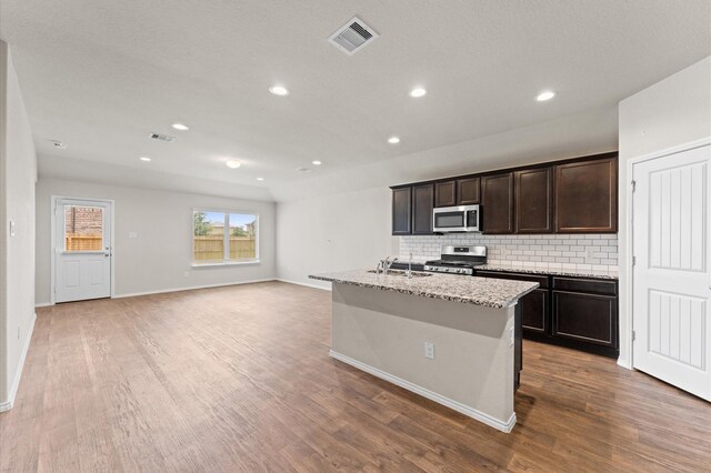 919 Bright Lotus Ln, Rosharon, TX 77583 - kitchen with appliances with stainless steel finishes, decorative backsplash, wood finished floors, recessed lighting, and dark brown cabinets