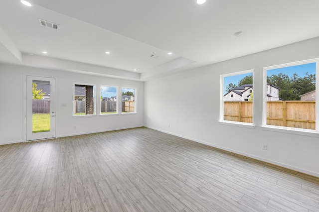 1235 Buffalo Run, Tomball, TX 77375 - unfurnished living room with healthy amount of natural light, a raised ceiling, light wood-style flooring, and recessed lighting