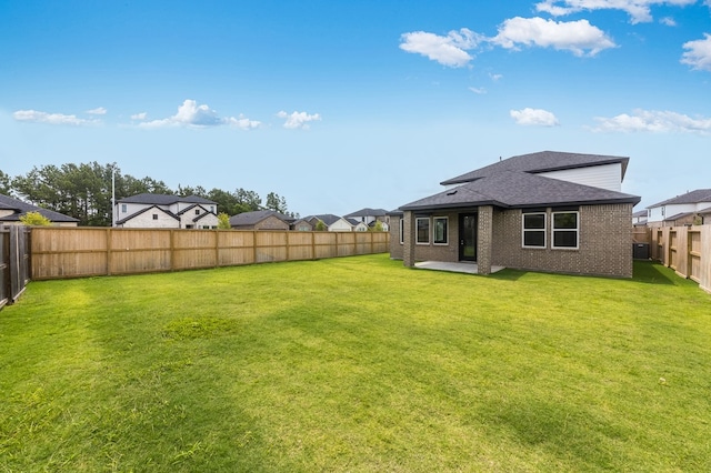 1235 Buffalo Run, Tomball, TX 77375 - back of house featuring a fenced backyard, brick siding, a shingled roof, and a patio