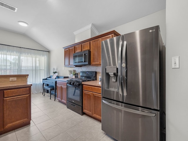 13022 Echo Landing Dr, Houston, TX 77070 - kitchen featuring stainless steel fridge, gas stove, vaulted ceiling, tasteful backsplash, and light tile patterned flooring