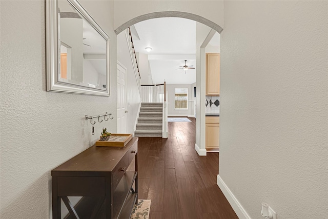20014 Coyote Ridge Ln, Katy, TX 77449 - hallway with arched walkways, dark wood-style flooring, a textured wall, and stairs
