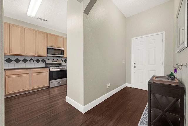 20014 Coyote Ridge Ln, Katy, TX 77449 - kitchen featuring stainless steel appliances, light brown cabinetry, dark wood-style floors, decorative backsplash, and dark countertops