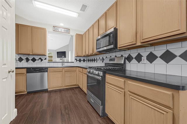20014 Coyote Ridge Ln, Katy, TX 77449 - kitchen featuring stainless steel appliances, dark countertops, dark wood-style floors, decorative backsplash, and a textured ceiling
