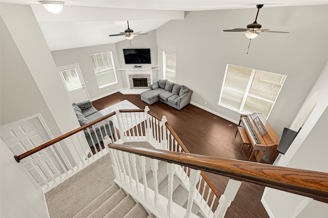 20014 Coyote Ridge Ln, Katy, TX 77449 - stairs featuring a ceiling fan, wood finished floors, a fireplace with raised hearth, high vaulted ceiling, and beamed ceiling