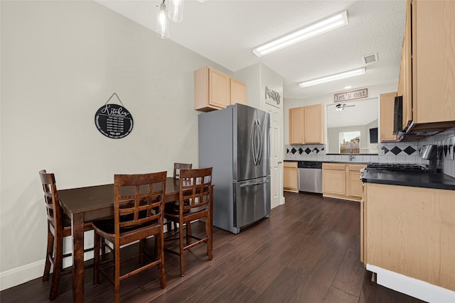 20014 Coyote Ridge Ln, Katy, TX 77449 - kitchen with appliances with stainless steel finishes, light brown cabinets, dark countertops, and decorative backsplash
