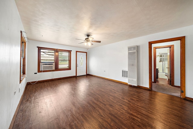 523 Main St, La Marque, TX 77568 - empty room with a heating unit, ceiling fan, dark wood-style floors, cooling unit, and a textured ceiling