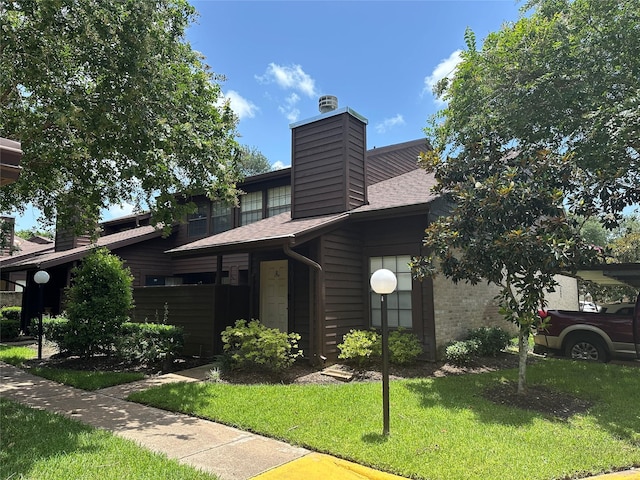 2510 Grants Lake Blvd Unit 101, Sugar Land, TX 77479 - view of front of home featuring a chimney, a front lawn, and a shingled roof