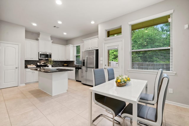 134 Biltmore Loop, Montgomery, TX 77316 - kitchen featuring stainless steel appliances, a kitchen island, decorative backsplash, white cabinetry, and dark countertops