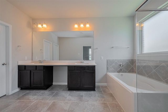 8326 Erasmus Landing Ct, Houston, TX 77044 - bathroom featuring double vanity, a garden tub, and stone finish flooring