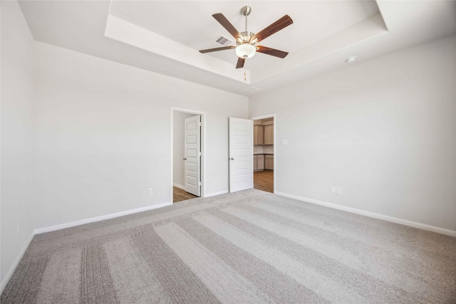 22408 Kinley St, New Caney, TX 77357 - unfurnished bedroom featuring a raised ceiling, carpet floors, and a ceiling fan
