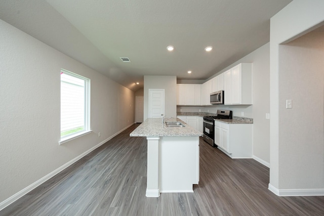 2569 Hawks Eye Dr, Conroe, TX 77301 - kitchen with appliances with stainless steel finishes, dark wood-style flooring, white cabinetry, light stone counters, and recessed lighting