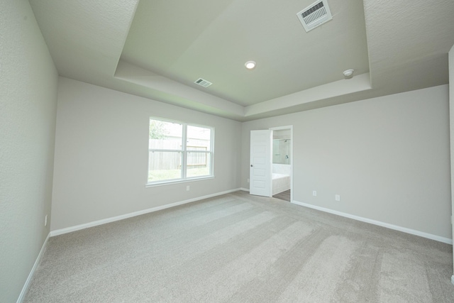 2569 Hawks Eye Dr, Conroe, TX 77301 - unfurnished bedroom featuring a tray ceiling, carpet, and ensuite bath