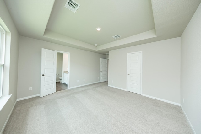 2569 Hawks Eye Dr, Conroe, TX 77301 - unfurnished bedroom with a raised ceiling, carpet, and connected bathroom