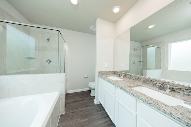 2569 Hawks Eye Dr, Conroe, TX 77301 - bathroom featuring a stall shower, a garden tub, double vanity, wood finished floors, and recessed lighting