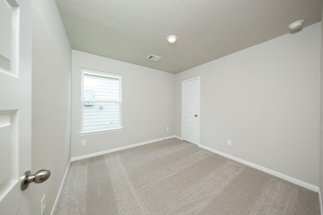 2569 Hawks Eye Dr, Conroe, TX 77301 - empty room with a smoke detector, light carpet, and a textured ceiling