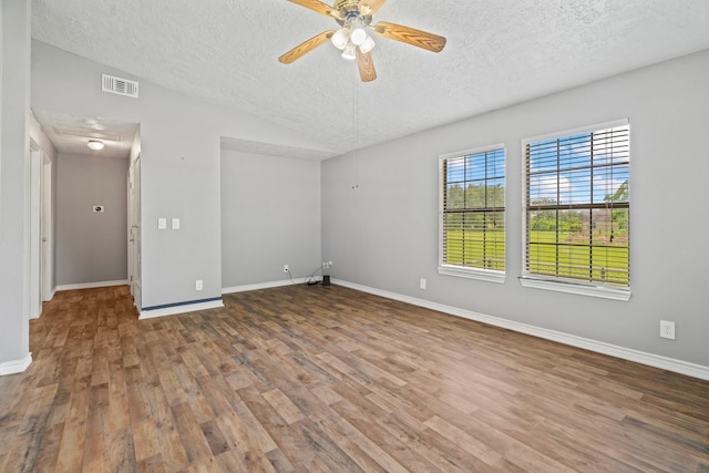 501 Carlson Cir, Wharton, TX 77488 - spare room featuring a textured ceiling, wood finished floors, a ceiling fan, and vaulted ceiling