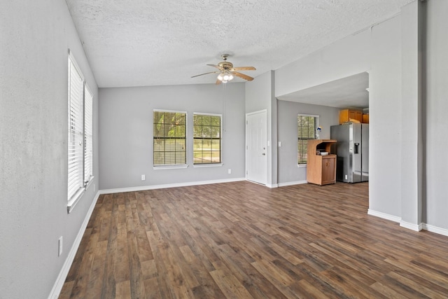 501 Carlson Cir, Wharton, TX 77488 - unfurnished living room featuring a ceiling fan, dark wood-style flooring, lofted ceiling, and a textured ceiling