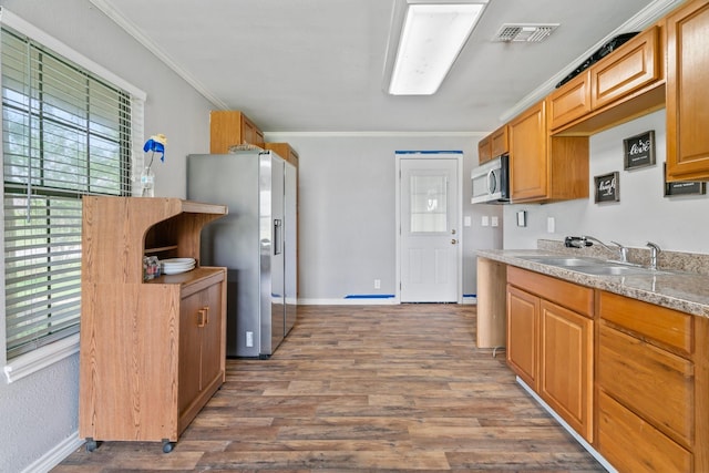 501 Carlson Cir, Wharton, TX 77488 - kitchen with stainless steel appliances, ornamental molding, wood finished floors, and light countertops