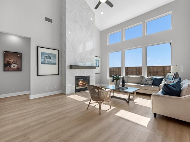 14316 Moonlit Creek Ct, Montgomery, TX 77316 - living area with high vaulted ceiling, ceiling fan, wood finished floors, a premium fireplace, and baseboards