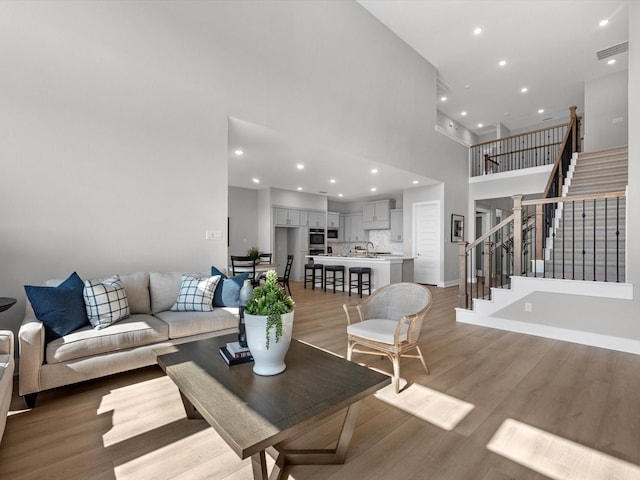 14316 Moonlit Creek Ct, Montgomery, TX 77316 - living area featuring stairway, light wood finished floors, recessed lighting, and a towering ceiling