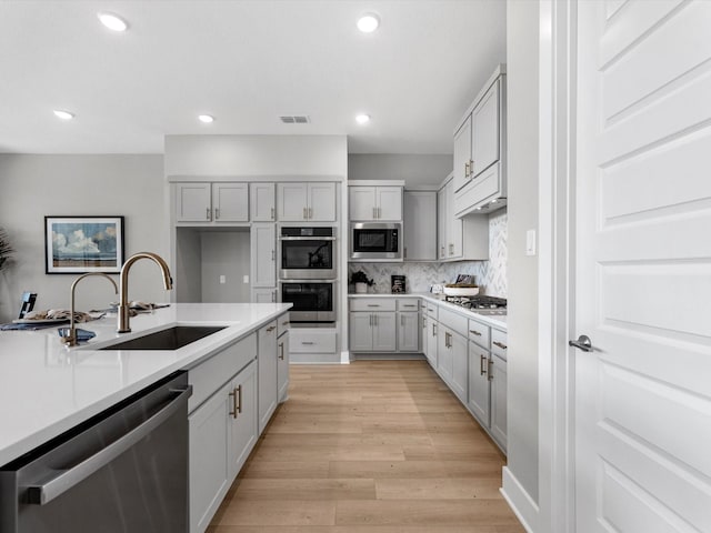 14316 Moonlit Creek Ct, Montgomery, TX 77316 - kitchen with appliances with stainless steel finishes, a sink, gray cabinets, and recessed lighting