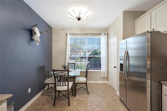 2818 Lake Forest Dr, Montgomery, TX 77356 - dining space with a textured ceiling, light tile patterned floors, and a chandelier