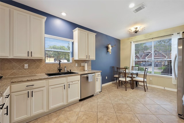 2818 Lake Forest Dr, Montgomery, TX 77356 - kitchen with stainless steel appliances, decorative backsplash, light tile patterned flooring, white cabinets, and recessed lighting