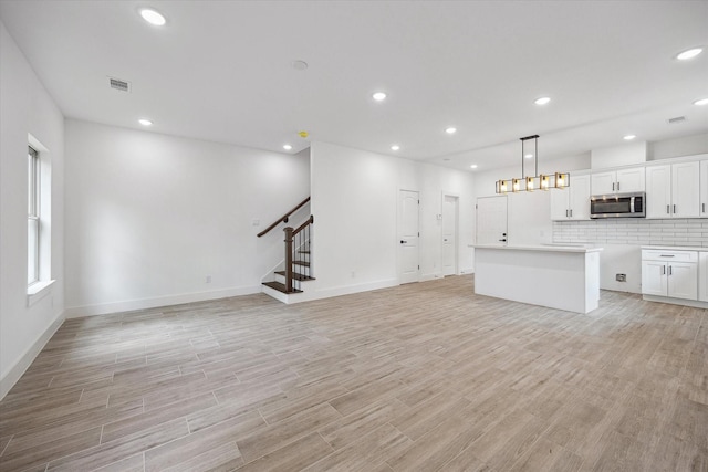 2015 Brackenridge St Unit B, Houston, TX 77026 - unfurnished living room featuring stairs, light wood-style flooring, and recessed lighting