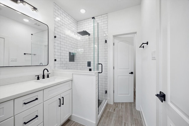 2015 Brackenridge St Unit B, Houston, TX 77026 - bathroom featuring vanity, a stall shower, wood finish floors, and recessed lighting