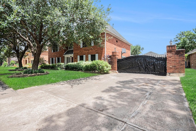 2128 Wimbleton Ct, Pearland, TX 77581 - view of front facade with a gate, brick siding, concrete driveway, and a front yard