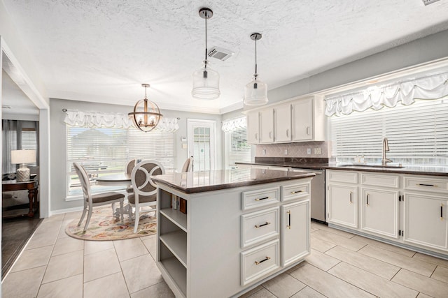 2128 Wimbleton Ct, Pearland, TX 77581 - kitchen with dishwasher, a center island, white cabinets, a chandelier, and decorative light fixtures