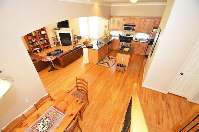 1331 W 21st St Unit A, Houston, TX 77008 - kitchen with appliances with stainless steel finishes, light wood finished floors, crown molding, light brown cabinets, and open floor plan
