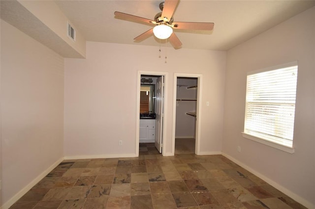 1331 W 21st St Unit A, Houston, TX 77008 - unfurnished bedroom featuring a walk in closet, stone finish flooring, a closet, and a ceiling fan