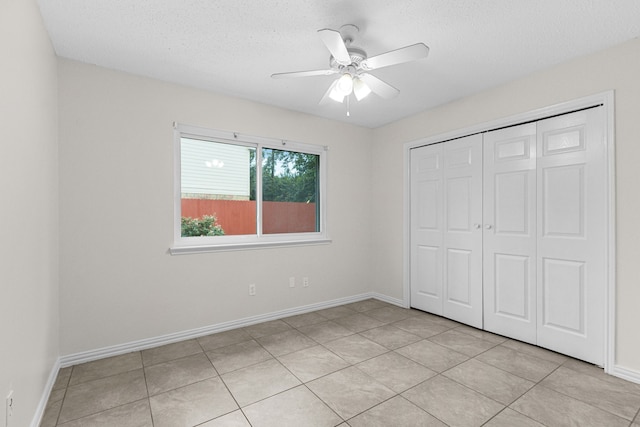 9803 Haverdown Dr, Houston, TX 77065 - unfurnished bedroom featuring a closet, light tile patterned flooring, a textured ceiling, and a ceiling fan